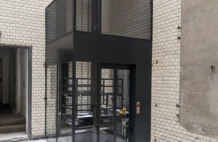 Maßgefertigte Aufzugseinhausung aus Stahl im Innenhof eines Gebäudes in Berlin
