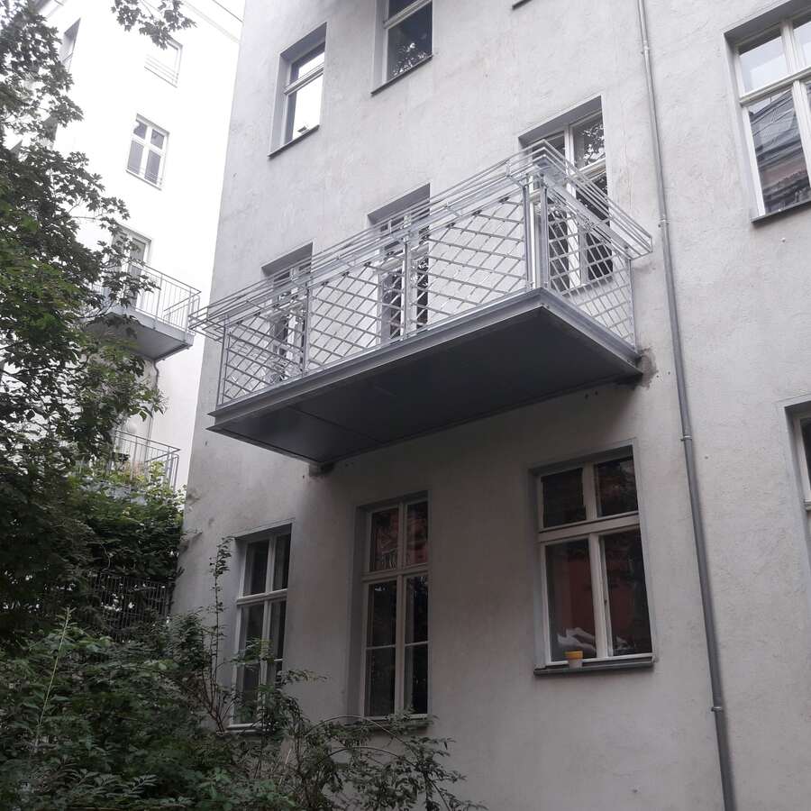 Stahlbalkon mit verzinktem Geländer an der Fassade eines Wohnhauses in Berlin